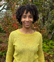 An image of an african american woman in yellow sweater